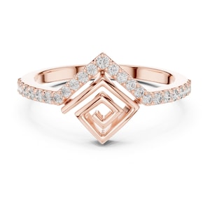 May include: Rose gold ring with a geometric design. The ring features a square spiral centre and a V-shaped top, both adorned with small, sparkling diamonds. The band is also embellished with diamonds.