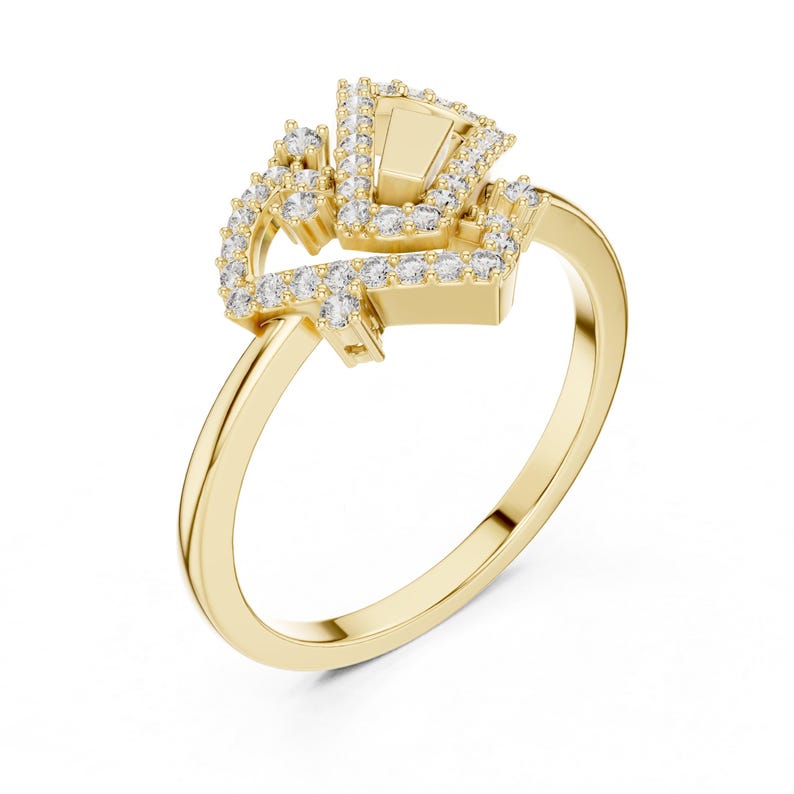 May include: A gold ring with a unique design. The ring features a central rectangular stone surrounded by smaller, clear stones. The band is a simple, polished gold. The ring is set against a white background, highlighting its intricate details.