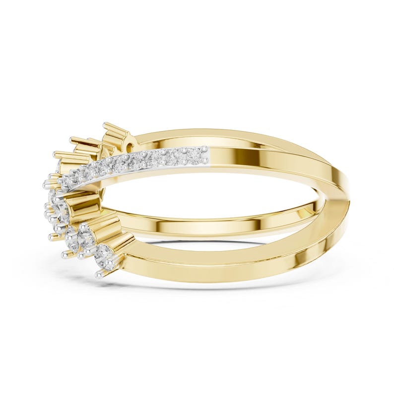 K&ouml;nnte beinhalten: Ein goldfarbener Ring mit einem Doppelband-Design. Das obere Band weist eine Reihe kleiner, klarer Edelsteine auf. Der Ring hat einen modernen, eleganten Stil, der f&uuml;r verschiedene Anl&auml;sse geeignet ist.