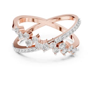 K&ouml;nnte beinhalten: Ring in Ros&eacute;gold-Optik mit einem Kreuzmuster. Ein Band ist mit kleinen, klaren Kristallen besetzt, w&auml;hrend das andere schlicht ist. An dem mit Kristallen besetzten Band sind Gruppen gr&ouml;&szlig;erer, klarer Kristalle angeordnet.