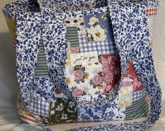 Könnte beinhalten: Eine Patchwork-Tragetasche mit einer Vielzahl von Stoffen mit Blumenmustern in Blau-, Rosa-, Rot- und Gelbtönen. Die Tasche hat ein blaues Blumenmusterfutter und Träger mit dem Text "just for you" auf einem Aufnäher.