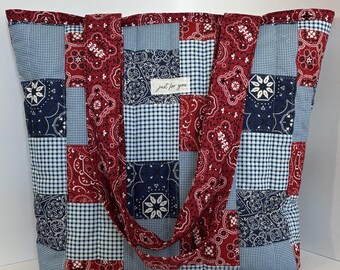Könnte beinhalten: Eine große Patchwork-Tragetasche mit einer Mischung aus rotem Paisley, marineblauem Blumenmuster und hellblauem Vichy-Stoff. Die Tasche hat zwei Griffe und ein Etikett mit der Aufschrift "just for you".