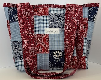 Könnte beinhalten: Eine gesteppte Tragetasche mit einem Patchwork-Design aus roten und marineblauen Bandana-Mustern, kombiniert mit blau-weißen Vichy-Karos. Ein weißes rechteckiges Stoffetikett ist in der Mitte mit dem Text just for you aufgenäht.
