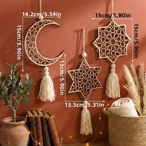 May include: Wooden decorative wall hangings in the shape of a crescent moon, a five-pointed star, and an eight-pointed star. Each piece is 5.90 inches tall and features a geometric cutout design. The moon is 5.59 inches wide, and the star is 5.31 inches wide. Each has a tassel.