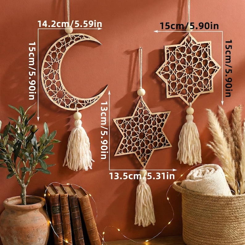 May include: Wooden decorative wall hangings in the shape of a crescent moon, a five-pointed star, and an eight-pointed star. Each piece is 5.90 inches tall and features a geometric cutout design. The moon is 5.59 inches wide, and the star is 5.31 inches wide. Each has a tassel.
