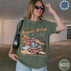 May include: A white ceramic mug with a black handle and the text "But First, Coffee" in a handwritten style. The mug is on a white surface. The mug is 4 inches tall.