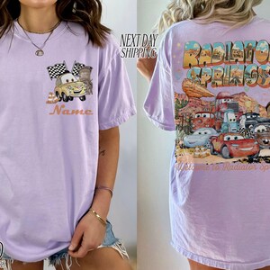 Puede incluir: Una taza de cer&aacute;mica blanca con un asa negra y el texto "But First, Coffee" en negro, con una fuente de estilo manuscrito. La taza est&aacute; sobre una superficie blanca.