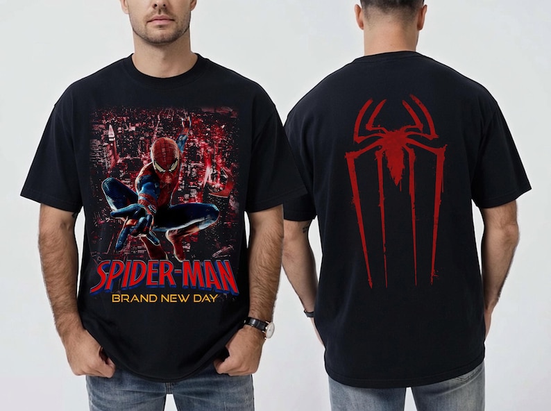 以下が含まれることがあります： スパイダーマンが都市の背景を前にダイナミックなポーズをとっている黒いTシャツ。「SPIDER-MAN BRAND NEW DAY」の文字が赤と青で表示されています。背面には赤いクモのシンボルがあります。