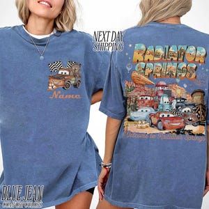 Puede incluir: Una taza de cer&aacute;mica blanca con asa negra y el texto "But First, Coffee" en negrita negra. La taza se encuentra sobre un fondo borroso, sugiriendo un ambiente acogedor.