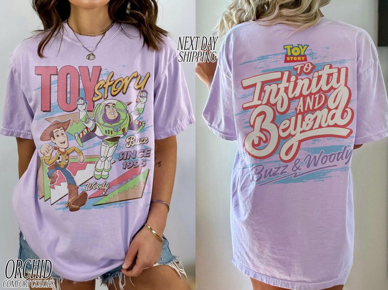 K&ouml;nnte beinhalten: Helllila T-Shirt mit den Toy Story-Charakteren Woody und Buzz Lightyear. Auf der Vorderseite stehen "Toy Story" und "Buzz Since 1995". Auf der R&uuml;ckseite steht "To Infinity and Beyond" und "Buzz & Woody".