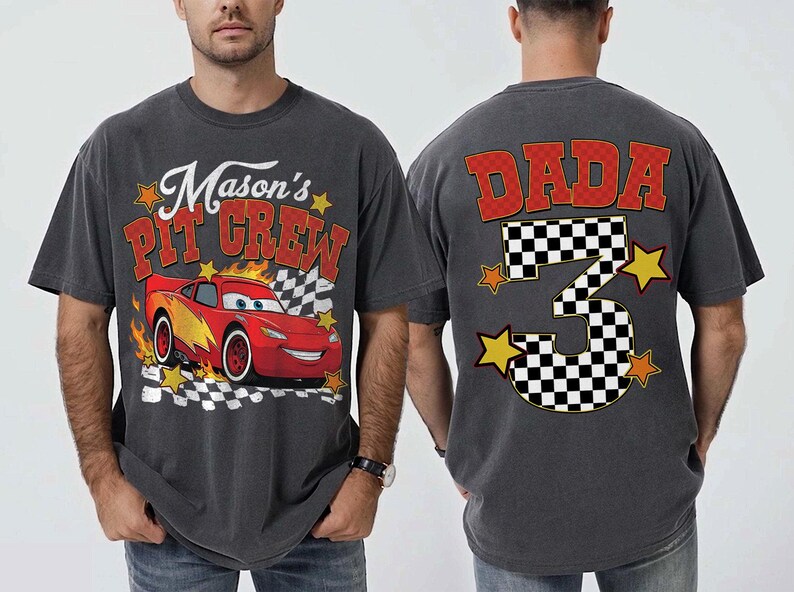 Peut inclure: T-shirt gris fonc&eacute; avec un dessin de voiture de course rouge et le texte "Mason's Pit Crew". Le dos du t-shirt affiche "DADA" et un num&eacute;ro 3 &agrave; damier avec des &eacute;toiles, parfait pour un anniversaire.
