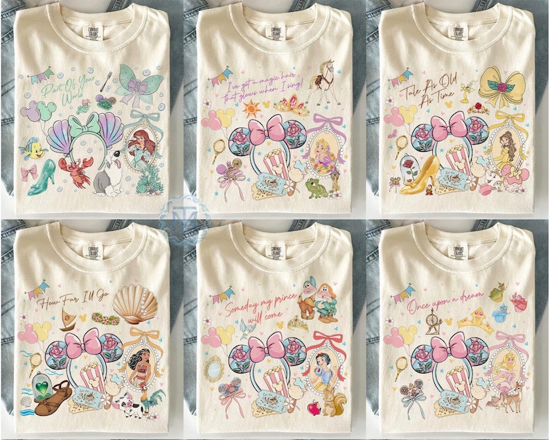 May include: Cream-colored t-shirts with various Disney princess-themed designs. Each shirt features a different princess, along with related imagery and text. Designs include Ariel, Rapunzel, Belle, Moana, Snow White, and Cinderella.
