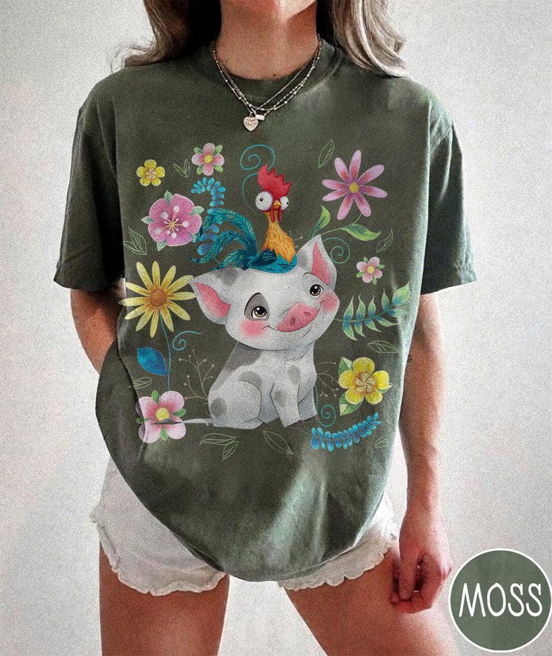 Pu&ograve; includere: T-shirt verde muschio con un design a fumetto di maiale e gallo, circondato da fiori e foglie colorate. L'illustrazione ha uno stile allegro e stravagante. La maglietta ha una vestibilit&agrave; ampia e maniche corte.