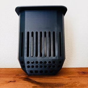 Pode incluir: Uma caneca de cerâmica artesanal com uma cobertura salpicada de cor creme. A caneca apresenta um corpo largo e arredondado e uma pega robusta. O interior é de um tom mais escuro e contrastante. Adequada para bebidas quentes ou frias.