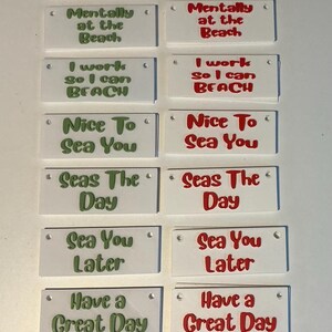 May include: A collection of white rectangular signs with various beach-themed phrases in green and red lettering. Phrases include "Out of Office," "Mentally at the Beach," and "Sea You Later."
