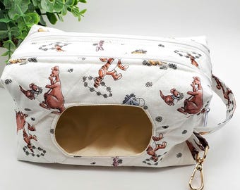 May include: White quilted fabric wipe case with a cartoon character pattern. The case has a rectangular opening, a zipper closure, and a gold-colored clasp. The pattern features brown, orange, and blue characters.