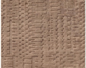 May include: A rectangular, brown rug with a textured, raised pattern. The design features a series of horizontal and vertical rectangular shapes, creating a layered effect. The rug's color is a warm, neutral tone, suitable for various interior styles.