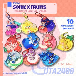 Może przedstawiać: Kolekcja przezroczystych akrylowych breloków do kluczy z postaciami z Sonic the Hedgehog połączonymi z owocowymi wzorami. Każdy brelok ma wymiary około 5,8 x 5,8 cm i posiada zapięcie na karabińczyk. Tekst "SONIC X FRUITS" jest widoczny na górze.