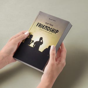 May include: A book-shaped gift box with the title "OUR TRUE FRIENDSHIP" in large, bold letters. The cover features a silhouette of three people against a yellow and orange sunset. The text "The tale of two hearts, side by side" is also visible.