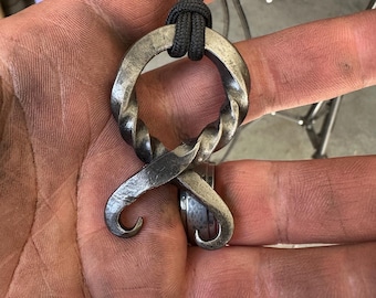 Colgante de cruz de trol forjado a mano.