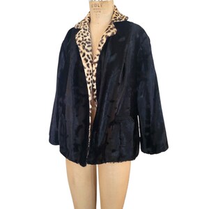Peut inclure: Une veste en fausse fourrure noire avec une doublure à imprimé léopard. La veste a un col et des manches longues.