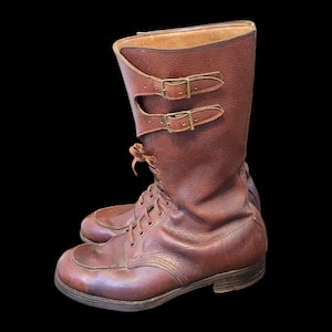 May include: Brown leather boots with laces and buckles. The boots have a pointed toe and a thick sole.