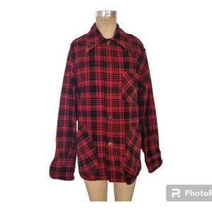May include: A red and black plaid shirt with long sleeves, a collar, and two front pockets. The shirt is buttoned up and displayed on a mannequin. The fabric appears to be a soft, woven material.