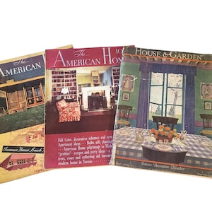 May include: Three vintage magazines from the 1920s or 1930s. The American Home magazine features a living room with a fireplace and a red armchair. House & Garden magazine features a dining room with a table set for a meal. The American Home magazine features a summer home on the beach.
