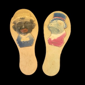 Matracas antiguas. Paletas. Un par. Fabricadas en Alemania. Rana o sapo con cara negra. Años 1900 aproximadamente. Cartón grueso. Recuerdo de juguete antiguo.