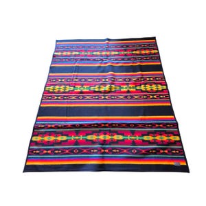 May include: A rectangular, dark blue blanket with a vibrant, geometric pattern. The design incorporates horizontal stripes in red, orange, yellow, green, and blue, with detailed, colorful motifs. The blanket is likely made of a soft, woven material.