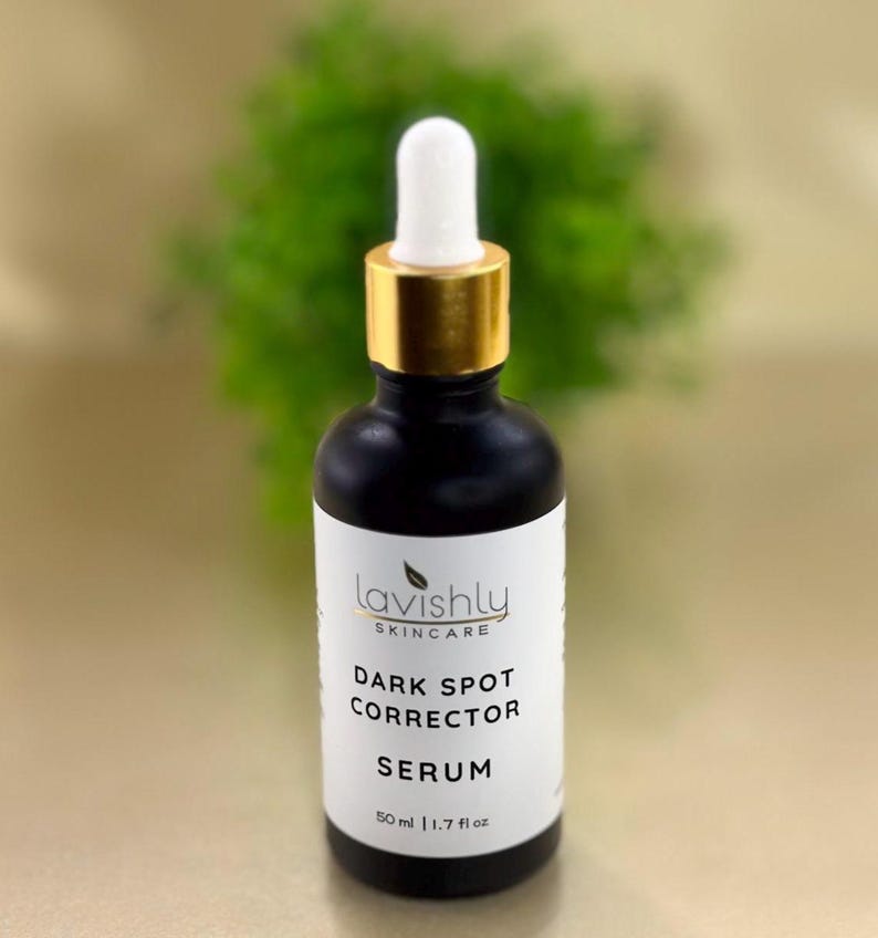 May include: A black skincare serum bottle with a white label featuring the text "Lavishly Skincare Dark Spot Corrector Serum". The bottle has a gold-colored top and a white dropper. The bottle contains 1.7 fl oz of serum.