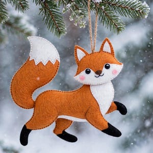 May include: A felt fox ornament featuring a vibrant orange body, a white chest, a white-tipped tail, and black paws. The fox has stitched details, pink cheeks, and black eyes. It hangs from a brown twine loop, designed for display as a decoration.