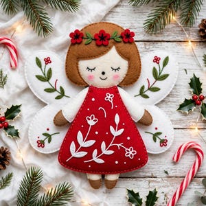 May include: A felt angel ornament featuring a red dress with white floral embroidery, white wings with green leaf stitching, and a brown-haired head adorned with a red flower crown. The figure has closed eyes, pink cheeks, and brown hands and feet.