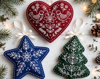 May include: Three felt ornaments with white embroidered patterns: a red heart featuring birds and flowers, a blue star with a central floral motif, and a green Christmas tree with leaf designs. Each ornament has a white ribbon loop for hanging.