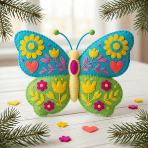 May include: A colorful felt butterfly decoration with blue, green, yellow, pink, and red accents. The butterfly features floral and heart designs, with a yellow body and antennae. This handcrafted item is perfect for home decor.