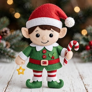 May include: A felt elf ornament featuring a red and white hat with a pom-pom, a green tunic with two red buttons, a red belt with a buckle, and striped leggings. The elf holds a red and white candy cane and a small yellow star ornament.