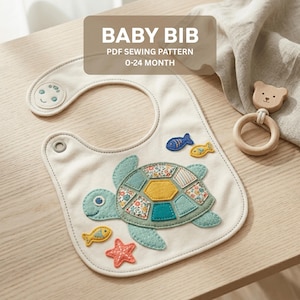 May include: Cream-colored baby bib with a turtle applique and fish and starfish accents. The bib has a rounded shape with a snap closure and a small smiling face detail. The text "BABY BIB PDF SEWING PATTERN 0-24 MONTH" is displayed.