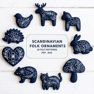 Könnte beinhalten: Eine Sammlung dunkelblauer Filzornamente mit weiß gestickten Blumen- und Volkskunstmustern in Form von Vogel, Elch, Pferd, Igel, Herz, Hase, Pilz, Bär und Katze, mit dem Text SCANDINAVIAN FOLK ORNAMENTS 10 FELT PATTERNS PDF . SVG.
