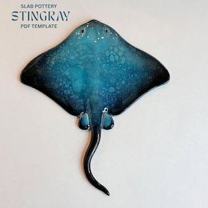 May include: A ceramic stingray sculpture featuring a gradient of deep blue to turquoise with a bubble-like texture pattern. The text SLAB POTTERY STINGRAY PDF TEMPLATE is visible in the upper left corner of the image.
