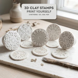May include: A set of five white circular clay stamps featuring intricate floral and geometric patterns, accompanied by five matching clay impressions. A text overlay reads: 3D CLAY STAMPS PRINT YOURSELF 5 PATTERNS - STL -SVG -PDF.