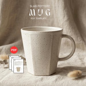 Może przedstawiać: Nakrapiany, kremowobiały ceramiczny kubek o geometrycznym kształcie i zaokrąglonym uchwycie. Na kubku widnieje napis "SLAB POTTERY MUG PDF TEMPLATE". Widoczna jest ikona PDF oraz kilka wydruków szablonów.