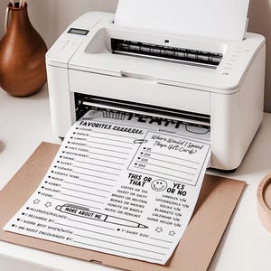 May include: A white printer printing a black and white questionnaire. The questionnaire includes sections for favorites, gift card spending, and a 'This or That' section. The paper is printed on a brown cardboard surface.