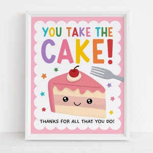 May include: A framed print with a pink background and the words "YOU TAKE THE CAKE!" in colorful letters. A cartoon slice of cake with a cherry on top is featured, along with the text "THANKS FOR ALL THAT YOU DO!" and star illustrations.