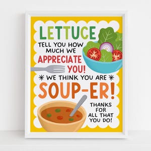 May include: A framed print with a yellow background and white border. The print features the words "LETTUCE TELL YOU HOW MUCH WE APPRECIATE YOU! * WE THINK YOU ARE * SOUP-ER! THANKS FOR ALL THAT YOU DO!" with illustrations of salad and soup.