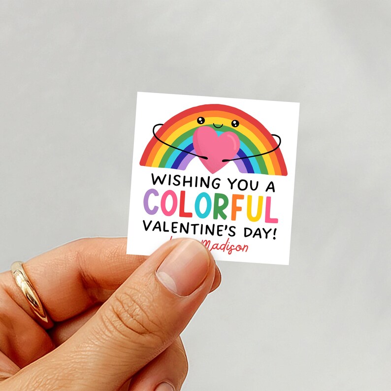 May include: A square sticker with a rainbow design holding a pink heart. The text reads "Wishing You a Colorful Valentine's Day!" with the name "Madison" below. The rainbow has a smiling face.