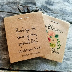 Pu&ograve; includere: Due pacchetti di carta marrone con testo bianco. Il primo pacchetto dice "Thank you for sharing this special day! Wildflower Seeds SULUGIFTS.ETSY.COM". Il secondo pacchetto dice "e Blossoms... Shower".
