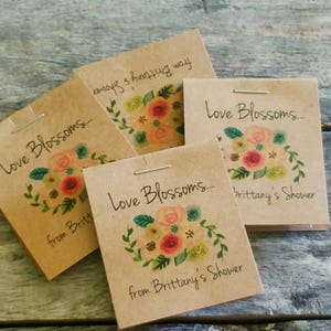 Pu&ograve; includere: Quattro sacchetti di carta marrone con un motivo floreale e il testo "Love Blossoms... from Brittany's Shower".
