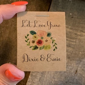 Pu&ograve; includere: Un sacchetto di semi di carta marrone con un disegno floreale e il testo "Let Love Grow" e "Dixie & Ernie".