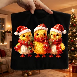 May include: Black pillowcase featuring three yellow chicks wearing red and white Santa hats and scarves. Each chick holds a sprig of greenery. The chicks are set against a Christmas tree background.
