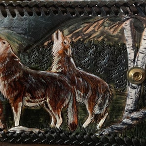 Un diseño original de lobos aullando a la luna creciente. Diseño de cuero tallado a mano en una billetera de hombre. Los lobos son mis favoritos.